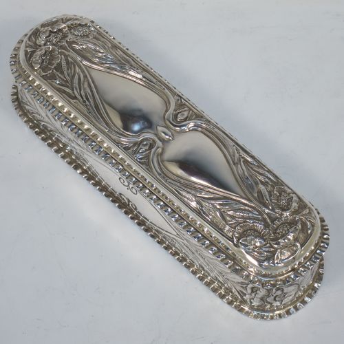 A bold and very pretty Antique Edwardian Sterling Silver Art Nouveau style table box, having a rounded rectangular body with hand-chased floral and scroll decoration, with crimped bead-edged borders and a gold-gilt interior, a hinged lid, and sitting on a flat base. Made by Nathan & Hayes of Birmingham in 1904. The dimensions of this fine hand-made antique silver Art Nouveau style box are length 20 cms (8 inches), width 6 cms (2.3 inches), height 5 cms (2 inches), and it weighs approx. 160g (5.2 troy ounces).