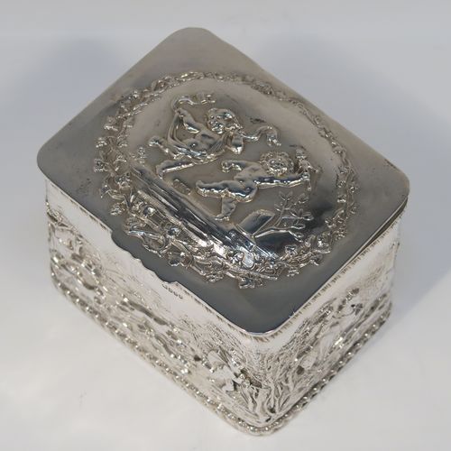 A beautiful Antique Victorian Sterling Silver table box, having a rectangular body with hand-chased figural hunting scenes and applied gadroon borders, a hinged lid with hand-chased grapevine and dancing cherubs, a gold-gilt interior, and sitting on a flat base. This very pretty antique sterling silver box has in importers mark for 1900. The dimensions of this fine hand-made antique silver box are length 9.5 cms (3.75 inches), width 7.5 cms (3 inches), height 6.5 cms (2.6 inches), and it weighs approx. 168g (5.4 troy ounces).