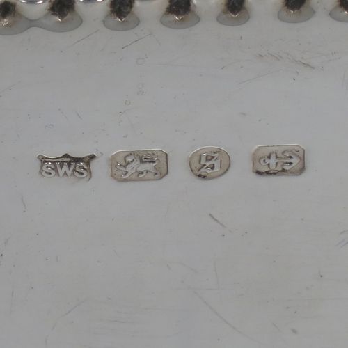 A very pretty Antique Victorian Sterling Silver table box, having a rectangular body with hand-chased floral and scroll decoration, a hinged lid with a vacant cartouche, a gold gilt interior, and sitting on a flat base. Made by Samuel Walton Smith of Birmingham in 1892. The dimensions of this fine hand-made antique silver box are height 6 cms (2.3 inches), length 12 cms (4.75 inches), width 9 cms (3.5 inches), and it weighs approx. 242g (7.8 troy ounces).