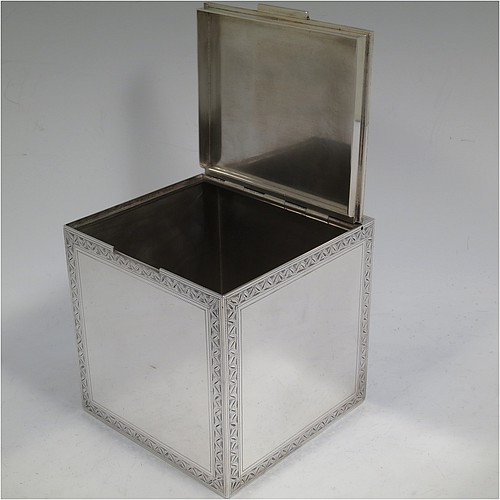 A very fine, unusual, and handsome heavy Sterling Silver table box, having a cube-shaped body, with an invisibly hinged lid, and hand-engraved with bright-cut floral leaf-work borders, and sitting on a flat base. Beautifully and skilfully hand-made made by Robert Comyns of London in 1938. The dimensions of this fine hand-made silver box are 11.5 cms (4.5 inches) cubed, and it weighs approx. 890g (29 troy ounces).