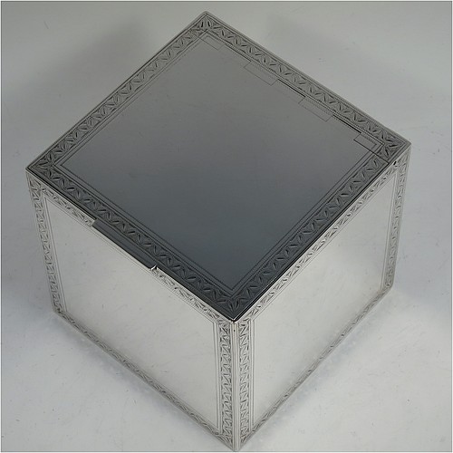 A very fine, unusual, and handsome heavy Sterling Silver table box, having a cube-shaped body, with an invisibly hinged lid, and hand-engraved with bright-cut floral leaf-work borders, and sitting on a flat base. Beautifully and skilfully hand-made made by Robert Comyns of London in 1938. The dimensions of this fine hand-made silver box are 11.5 cms (4.5 inches) cubed, and it weighs approx. 890g (29 troy ounces).