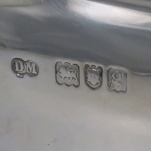An Antique Edwardian Sterling Silver hand-chased Bonbonnier style heavy table box, having a shaped oval baluster body with a hinged domed lid and thumb-piece, and sitting on four cast scroll feet. Made by David Munsey of London in 1902. The dimensions of this fine hand-made antique silver box are length 20 cms (8 inches), width 14 cms (5.5 inches), height 12.5 cms (5 inches), and it weighs approx. 806g (26 troy ounces).