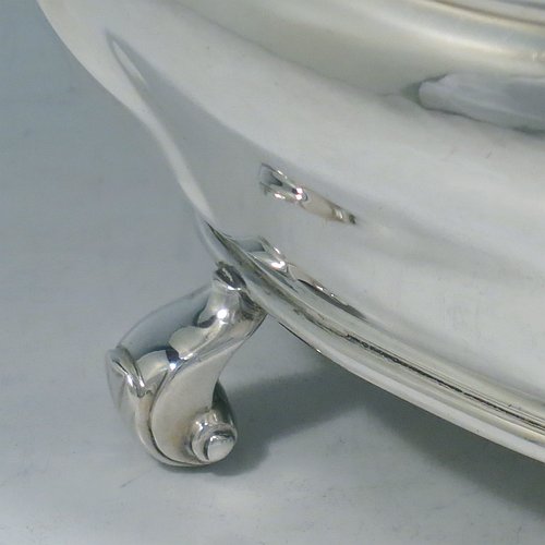 An Antique Edwardian Sterling Silver hand-chased Bonbonnier style heavy table box, having a shaped oval baluster body with a hinged domed lid and thumb-piece, and sitting on four cast scroll feet. Made by David Munsey of London in 1902. The dimensions of this fine hand-made antique silver box are length 20 cms (8 inches), width 14 cms (5.5 inches), height 12.5 cms (5 inches), and it weighs approx. 806g (26 troy ounces).