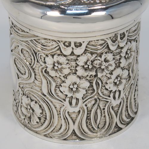 A very pretty Antique Edwardian Sterling Silver Art Nouveau style table box, having a round straight-sided body with hand-chased floral and scroll decoration, a pull-off lid with matching decoration and vacant central cartouche, a gold-gilt interior, and all sitting on a flat base. This beautiful Art Nouveau silver box was made by Synyer and Beddoes of Birmingham in 1903. The dimensions of this fine hand-made antique silver Art Nouveau style box are height 9 cms (3.5 inches), diameter 8 cms (3.25 inches), and it weighs approx. 130g (4.2 troy ounces).