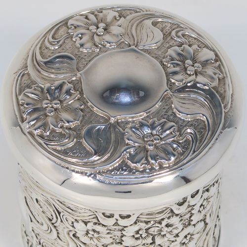 A very pretty Antique Edwardian Sterling Silver Art Nouveau style table box, having a round straight-sided body with hand-chased floral and scroll decoration, a pull-off lid with matching decoration and vacant central cartouche, a gold-gilt interior, and all sitting on a flat base. This beautiful Art Nouveau silver box was made by Synyer and Beddoes of Birmingham in 1903. The dimensions of this fine hand-made antique silver Art Nouveau style box are height 9 cms (3.5 inches), diameter 8 cms (3.25 inches), and it weighs approx. 130g (4.2 troy ounces).