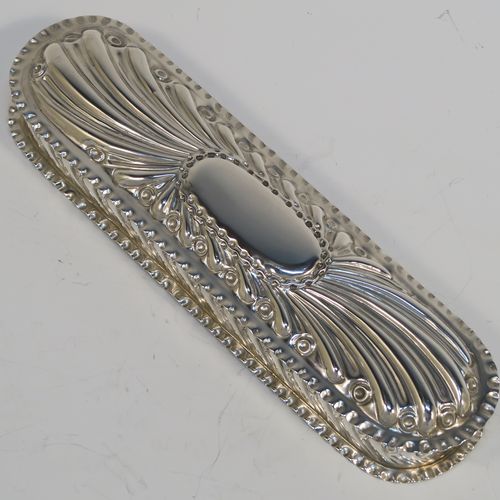 A beautiful Antique Victorian Sterling Silver Art Nouveau style table box, having a rounded rectangular body with hand-chased fluted and scroll decoration, with crimped bead-edged borders and a gold-gilt interior, a hinged lid with a vacant oval cartouche, and sitting on a flat base. This pretty antique silver box was made by Gibson and Langland of London in 1898. The dimensions of this fine hand-made antique silver Art Nouveau style box are length 17.5 cms (7 inches), width 5 cms (2 inches), height 2.5 cms (1 inch), and it weighs approx. 142g (4.6 troy ounces).