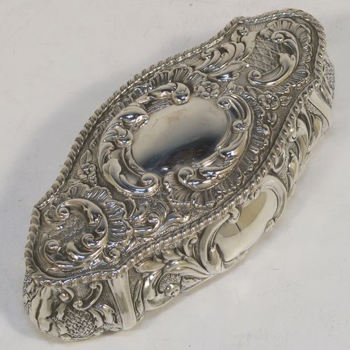 A very pretty Antique Edwardian Sterling Silver Art Nouveau style table box, having a lozenge shaped oval body with a gold-gilt interior hand-chased floral and scroll decoration, a hinged lid with a vacant central oval cartouche, and sitting on a flat base. This beautiful antique silver box was made by John Thompson of Birmingham in 1902. The dimensions of this fine hand-made antique silver Art Nouveau style box are length 13.5 cms (5.25 inches), width 6 cms (2.3 inches), height 4 cms (1.5 inches), and it weighs approx. 88g (2.8 troy ounces).  
