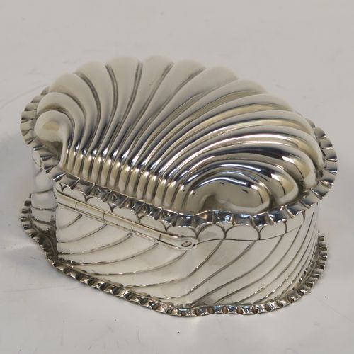 A very pretty Antique Victorian Sterling Silver shell style box, having a shell-shaped oval body with a gold-gilt interior, with hand-chased swirl fluted decoration, a hinged lid, and sitting on a flat base. This beautiful antique silver shell box was made by Horton and Allday of Birmingham in 1888. The dimensions of this fine hand-made antique silver shell style box are length 7.5 cms (3 inches), width 6 cms (2.3 inches), height 4 cms (1.5 inches), and it weighs approx. 57g (1.8 troy ounces).   