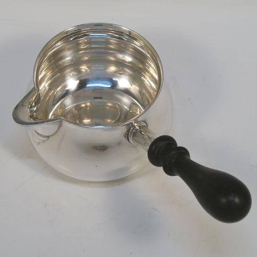 A handsome Antique Edwardian Sterling Silver brandy saucepan warmer, having a plain round bellied body, a sparrow-beak spout, an original wood turned handle, and sitting on a flat base. This elegant antique silver brandy or sauce warmer was made by William Abdy of London in ca. 1910 for the American market and is stamped with the Sterling word, and has been tested to 925 silver standard. The dimensions of this fine hand-made silver sauce or brandy warmer are height (inc. handle) 10 cms (4 inches), length (inc. handle) 19 cms (7.5 inches), diameter of main body 9 cms (3.5 inches), and it weighs approx. 200g (6.45 troy ounces).