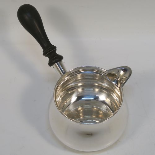 A handsome Antique Edwardian Sterling Silver brandy saucepan warmer, having a plain round bellied body, a sparrow-beak spout, an original wood turned handle, and sitting on a flat base. This elegant antique silver brandy or sauce warmer was made by William Abdy of London in ca. 1910 for the American market and is stamped with the Sterling word, and has been tested to 925 silver standard. The dimensions of this fine hand-made silver sauce or brandy warmer are height (inc. handle) 10 cms (4 inches), length (inc. handle) 19 cms (7.5 inches), diameter of main body 9 cms (3.5 inches), and it weighs approx. 200g (6.45 troy ounces).