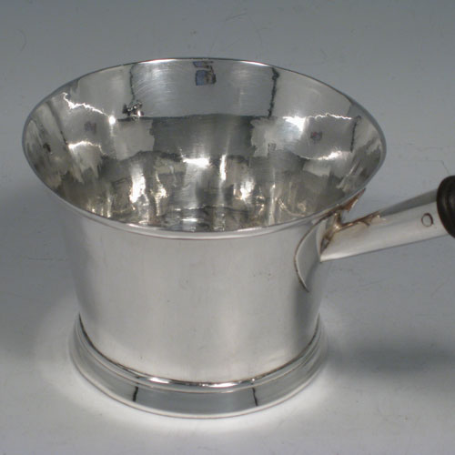    Antique Georgian sterling silver brandy saucepan warmer, having a plain round tapering straight-sided body, an original wood turned handle, and sitting on a collet foot. Made by John Albright of London in 1723. Height (inc. handle) 11 cms (4.25 inches), length (inc. handle) 19 cms (7.5 inches). Weight approx. 140g (4.5 troy ounces).