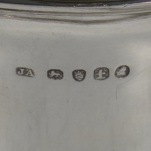 An Antique Georgian Sterling Silver brandy saucepan warmer, having a plain round tapering straight-sided body, a hinged domed lid with a cast goat finial and a hinged sparrow-beak spout, an original wood turned handle, with a gold-gilt interior, and all sitting on a reeded collet foot. Made by Joseph Angell I of London in 1821. The dimensions of this fine hand-made brandy saucepan warmer are height (inc. finial) 13 cms (5 inches), length (inc. handle) 22 cms (8.75 inches), and it weighs approx. 310g (10 troy ounces).