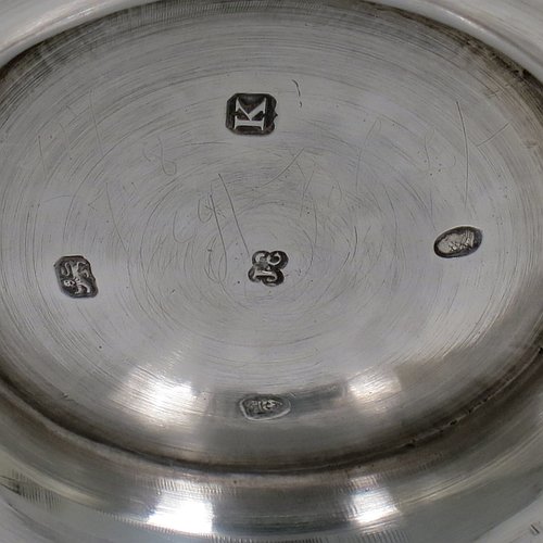 An Antique Georgian Sterling Silver brandy saucepan warmer, having a plain round body with tucked-under belly, an original pinned wood turned handle with heart-shaped cut-card mount, and all sitting on a reeded pedestal foot. Made by John Emes of London in 1805. The dimensions of this fine hand-made brandy saucepan warmer are height of main body 7.5 cms (3 inches), length (inc. handle) 22 cms (8.75 inches), and it weighs approx. 202g (6.5 troy ounces).