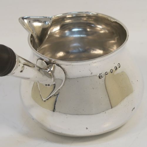 A handsome Antique Georgian Sterling Silver brandy saucepan warmer, having a plain round bellied body, a sparrow-beak spout, an original wood turned handle, and sitting on a flat base. This elegant antique silver brandy or sauce warmer was made by Thomas Oliphant of London in 1801. The dimensions of this fine hand-made silver sauce or brandy warmer are height (inc. handle) 15 cms (6 inches), length (inc. handle) 19 cms (7.5 inches), diameter of main body 9 cms (3.5 inches), and it weighs approx. 150g (4.8 troy ounces).