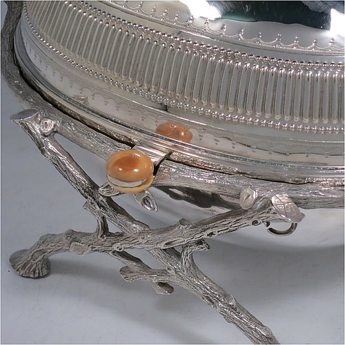 An Antique Victorian Silver Plated breakfast dish with revolving lid, and two original internal liners, having a hand-chased body with a fluted band and original bone button, all sitting in a cast frame with legs designed to look like naturalistic wooden branches. Made by the Fenton Brothers of Sheffield in ca. 1870. The dimensions of this fine hand-made antique silver-plated breakfast revolving serving dish are height 16.6 cms (6.5 inches), length 29 cms (11.5 inches), width 20 cms (8 inches).