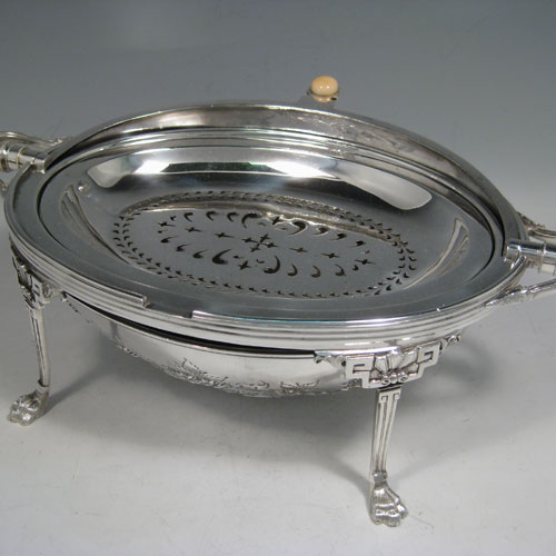 Antique Victorian silver-plated breakfast dish with revolving lid, original liners, and having hand-chased florally decorated body, sitting on four cast lions-paw feet. Made by Harrison Brothers and Howson of Sheffield in ca. 1880. Height 21 cms (8.25 inches), length 36 cms (14 inches), width 23 cms (9 inches).