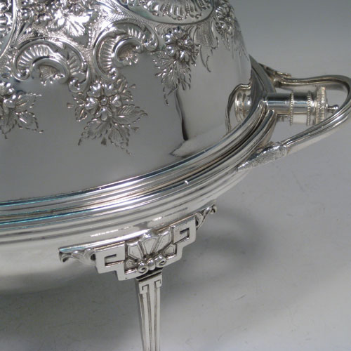 Antique Victorian silver-plated breakfast dish with revolving lid, original liners, and having hand-chased florally decorated body, sitting on four cast lions-paw feet. Made by Harrison Brothers and Howson of Sheffield in ca. 1880. Height 21 cms (8.25 inches), length 36 cms (14 inches), width 23 cms (9 inches).