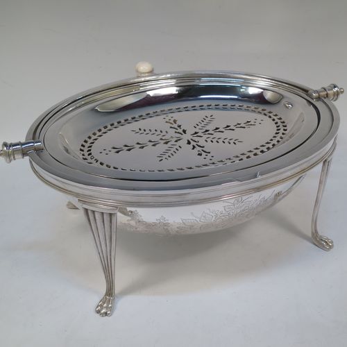 A very pretty Antique Victorian Silver Plated oval breakfast dish with revolving lid, and two original internal liners, having a hand-engraved body with floral and scroll decoration, an original bone insulated button, all sitting in a cast frame with fluted legs on lions-paw feet. Made by Mappin and Webb of Sheffield in ca. 1890. The dimensions of this fine hand-made antique silver-plated breakfast revolving serving dish are height 22 cms (8.5 inches), length 34 cms (13.5 inches), width 23 cms (9 inches).