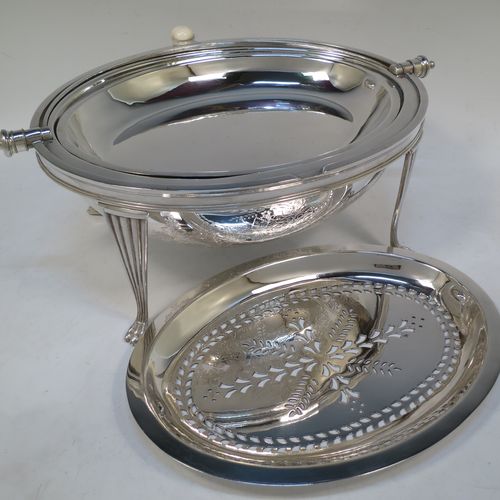 A very pretty Antique Victorian Silver Plated oval breakfast dish with revolving lid, and two original internal liners, having a hand-engraved body with floral and scroll decoration, an original bone insulated button, all sitting in a cast frame with fluted legs on lions-paw feet. Made by Mappin and Webb of Sheffield in ca. 1890. The dimensions of this fine hand-made antique silver-plated breakfast revolving serving dish are height 22 cms (8.5 inches), length 34 cms (13.5 inches), width 23 cms (9 inches).