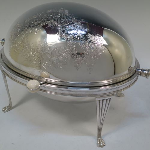 A very pretty Antique Victorian Silver Plated oval breakfast dish with revolving lid, and two original internal liners, having a hand-engraved body with floral and scroll decoration, an original bone insulated button, all sitting in a cast frame with fluted legs on lions-paw feet. Made by Mappin and Webb of Sheffield in ca. 1890. The dimensions of this fine hand-made antique silver-plated breakfast revolving serving dish are height 22 cms (8.5 inches), length 34 cms (13.5 inches), width 23 cms (9 inches).