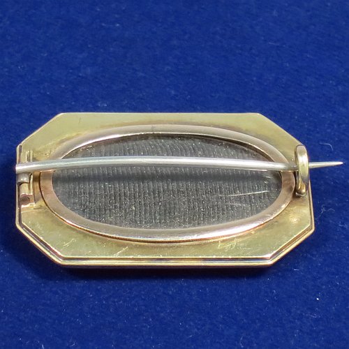 An Antique Victorian Aesthetic 15ct carat gold brooch, having an elongated hexagonal shaped body, with the front showing a hand-engraved scene with a bird sitting in a blossom tree, and the back having a pin with oval locket and glass cover. Made in ca. 1880. The dimensions of this fine antique gold brooch are length 3.5 cms (1.3 inches), width 2.3 cms (1 inch), and it weighs approx. 7g. Please note that the oval locket glass retainer is 9ct gold.
