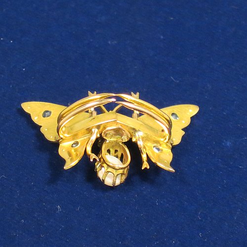 An Antique Victorian Aesthetic 9ct carat gold brooch, in the shape of a butterfly, with unusual mechanical articulated clasp on reverse, and having small rubies, sapphires, and pearls on the wings, with the eyes as rubies, the thorax as a larger sapphire, and the abdomen as an oval opal. Made in ca. 1880. The dimensions of this fine antique gold butterfly brooch are length 2 cms (0.75 inches), width 3 cms (1.25 inch), and it weighs approx. 3g.