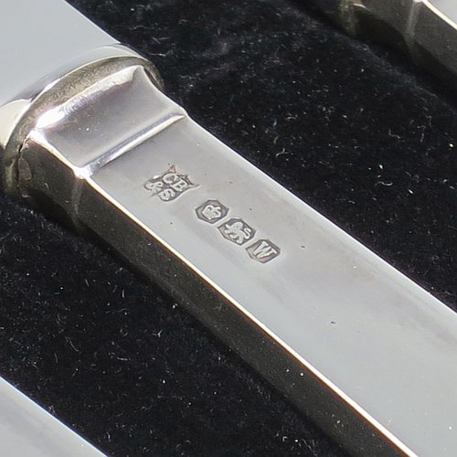 A Sterling Silver Art Deco style set of six butter or tea knives, having plain rectangular cross-section handles with reeded terminals, and plain finger-point stainless steel blades, all in their original cream satin and black velvet-lined presentation box. Made by Charles Boyton & Sons of Sheffield in 1939. The dimensions of this fine hand-made set of tea or butter knives are length of each knife 18 cms (7 inches), and the total weight is approx. 120g (4 troy ounces).