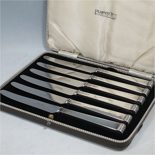 A Sterling Silver Art Deco style set of six butter or tea knives, having plain rectangular cross-section handles with reeded terminals, and plain finger-point stainless steel blades, all in their original cream satin and black velvet-lined presentation box. Made by Charles Boyton & Sons of Sheffield in 1939. The dimensions of this fine hand-made set of tea or butter knives are length of each knife 18 cms (7 inches), and the total weight is approx. 120g (4 troy ounces).
