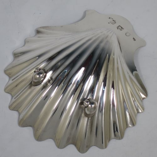 A very handsome Antique Georgian Sterling Silver butter shell, having a hand-chased traditional scallop shape, and sitting on two cast conch shell feet. Made by William Plummer of London in 1764. The dimensions of this fine hand-made antique silver butter shell are length 14 cms (5.5 inches), width 12 cms (4.75 inches), and with a weight of approx. 87g (2.8 troy ounces). Please note that this item is crested.