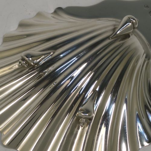A very handsome Antique Victorian Sterling Silver butter shell dish and butter knife, having a hand-chased scalloped body, and sitting on three cast conch-shell feet. The butter shell made by Francis Higgins of London in 1885, and the butter knife made by Charles Boyton of London in 1887. The dimensions of this fine hand-made antique silver butter dish shell are length 12 cms (4.75 inches), width 10 cms (4 inches), and the total weight including knife is approx 98g (3.2 troy ounces).