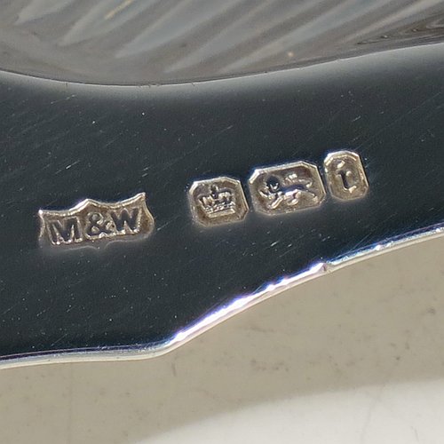 An Antique Victorian Sterling Silver pair of butter shells, having hand-chased scalloped bodies, plain shaped thumb-pieces, and both sitting on three ball feet. All made by Mappin & Webb of Sheffield in 1901. The dimensions of these fine hand-made antique silver butter dishes are length 12 cms (4.75 inches), width 9.5 cms (3.75 inches), height 2 cms (0.75 inches), and they have a total weight of approx. 146g (4.7 troy ounces).