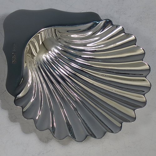 An Antique Victorian Sterling Silver pair of butter shells, having hand-chased scalloped bodies, plain shaped thumb-pieces, and both sitting on three ball feet. All made by Mappin & Webb of Sheffield in 1901. The dimensions of these fine hand-made antique silver butter dishes are length 12 cms (4.75 inches), width 9.5 cms (3.75 inches), height 2 cms (0.75 inches), and they have a total weight of approx. 146g (4.7 troy ounces).