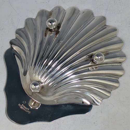 An Antique Victorian Sterling Silver pair of butter shells, having hand-chased scalloped bodies, plain shaped thumb-pieces, and both sitting on three ball feet. All made by Mappin & Webb of Sheffield in 1901. The dimensions of these fine hand-made antique silver butter dishes are length 12 cms (4.75 inches), width 9.5 cms (3.75 inches), height 2 cms (0.75 inches), and they have a total weight of approx. 146g (4.7 troy ounces).