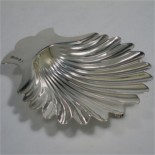A very handsome Antique Victorian Sterling Silver pair of butter shells, having hand-chased scalloped bodies, plain shaped thumb-pieces, and both sitting on three cast shell-shaped feet. All made by Walker and Hall of Sheffield in 1897/99. The dimensions of these fine hand-made antique silver butter dishes are length 13 cms (5 inches), width 11 cms (4.25 inches), height 2.5 cms (1 inch), and they have a total weight of approx. 163g (5.25 troy ounces).