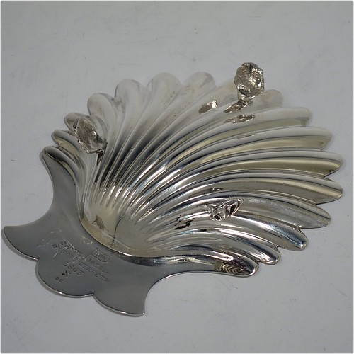 A very handsome Antique Victorian Sterling Silver pair of butter shells, having hand-chased scalloped bodies, plain shaped thumb-pieces, and both sitting on three cast shell-shaped feet. All made by Walker and Hall of Sheffield in 1897/99. The dimensions of these fine hand-made antique silver butter dishes are length 13 cms (5 inches), width 11 cms (4.25 inches), height 2.5 cms (1 inch), and they have a total weight of approx. 163g (5.25 troy ounces).