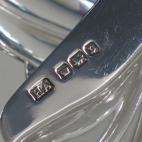 An Antique Sterling Silver pair of butter shells, having hand-chased scalloped bodies, plain shaped thumb-pieces, and both sitting on three ball feet. All made by Henry Atkins of Sheffield in 1913. The dimensions of these fine hand-made antique silver butter dishes are length 12 cms (4.75 inches), width 10 cms (4 inches), height 2.5 cms (1 inch), and they have a total weight of approx. 113g (3.6 troy ounces).