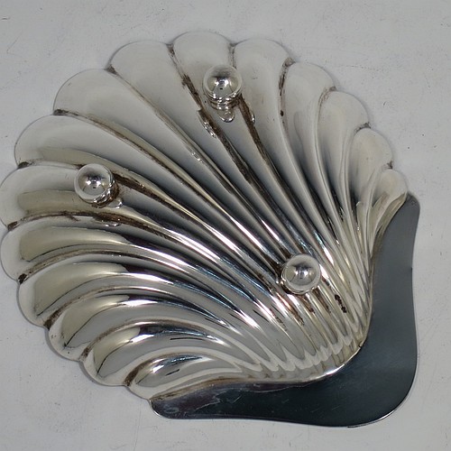An Antique Sterling Silver pair of butter shells, having hand-chased scalloped bodies, plain shaped thumb-pieces, and both sitting on three ball feet. All made by Henry Atkins of Sheffield in 1913. The dimensions of these fine hand-made antique silver butter dishes are length 12 cms (4.75 inches), width 10 cms (4 inches), height 2.5 cms (1 inch), and they have a total weight of approx. 113g (3.6 troy ounces).