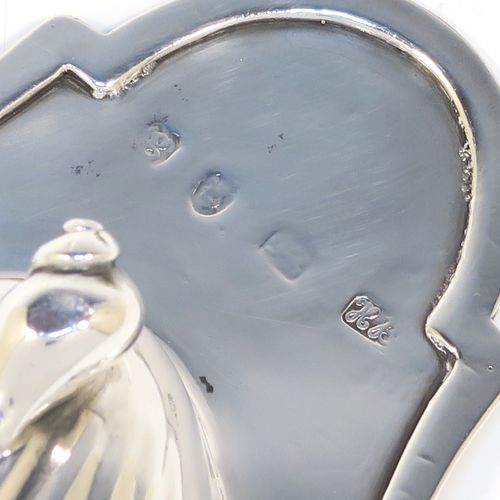 A very handsome pair of Antique Georgian Sterling Silver butter shells, having hand-chased scalloped bodies, shaped thumb-pieces with hand-engraved floral borders, and both sitting on three cast Conch shell-shaped feet. These beautiful antique silver butter shells were made by Hester Bateman of London in 1782. The dimensions of these fine hand-made antique silver butter dish shells are length 15 cms (6 inches), width 12.5 cms (5 inches), and they have a total weight of approx. 211g (6.8 troy ounces).