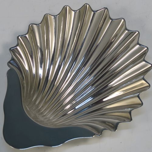 A handsome Antique Sterling Silver pair of butter shells, having traditional scallop shapes, and sitting on three ball feet, together with a pair of original butter knives, and all sitting in their original blue satin and velvet-lined presentation box. All made by Roberts and Belk of London in 1914. The dimensions of this fine hand-made set of antique silver butter shells and knives are length 12.5 cms (5 inches), width 10 cms (4 inches), with a total weight of approx. 148g (4.8 troy ounces).