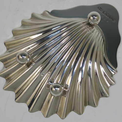 A handsome Antique Sterling Silver pair of butter shells, having traditional scallop shapes, and sitting on three ball feet, together with a pair of original butter knives, and all sitting in their original blue satin and velvet-lined presentation box. All made by Roberts and Belk of London in 1914. The dimensions of this fine hand-made set of antique silver butter shells and knives are length 12.5 cms (5 inches), width 10 cms (4 inches), with a total weight of approx. 148g (4.8 troy ounces).