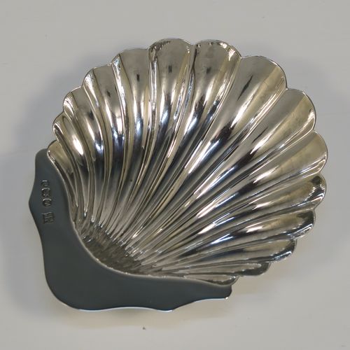 A very handsome Antique Victorian Sterling Silver butter shell and original butter knife, the shell having a hand-chased scalloped body, and sitting on three ball feet, the butter knife in the Old English Shell pattern, and all in their original blue satin and velvet-lined presentation box. Made by John & William Deakin of Sheffield in 1896. The dimensions of this fine hand-made antique silver butter dish and knife are length of dish 10 cms (4 inches), width 8.5 cms (3.25 inches), length of knife 10.5 cms (4.25 inches), and they weigh a total of approx 47g (1.5 troy ounces).