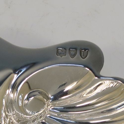 A pretty Antique Victorian Sterling Silver pair of butter shells, having hand-chased scalloped bodies, plain shaped thumb-pieces, and both sitting on three ball feet. These beautiful silver shell butter dishes were made by the Atkins Brothers of Sheffield in 1895. The dimensions of these fine hand-made antique silver butter dishes are length 12.5 cms (5 inches), width 10 cms (4 inches), and they have a total weight of approx. 124g (4 troy ounces).