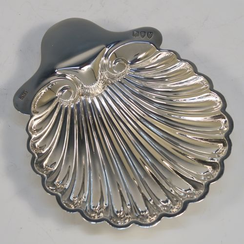 A pretty Antique Victorian Sterling Silver pair of butter shells, having hand-chased scalloped bodies, plain shaped thumb-pieces, and both sitting on three ball feet. These beautiful silver shell butter dishes were made by the Atkins Brothers of Sheffield in 1895. The dimensions of these fine hand-made antique silver butter dishes are length 12.5 cms (5 inches), width 10 cms (4 inches), and they have a total weight of approx. 124g (4 troy ounces).