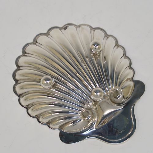 A pretty Antique Victorian Sterling Silver pair of butter shells, having hand-chased scalloped bodies, plain shaped thumb-pieces, and both sitting on three ball feet. These beautiful silver shell butter dishes were made by the Atkins Brothers of Sheffield in 1895. The dimensions of these fine hand-made antique silver butter dishes are length 12.5 cms (5 inches), width 10 cms (4 inches), and they have a total weight of approx. 124g (4 troy ounces).