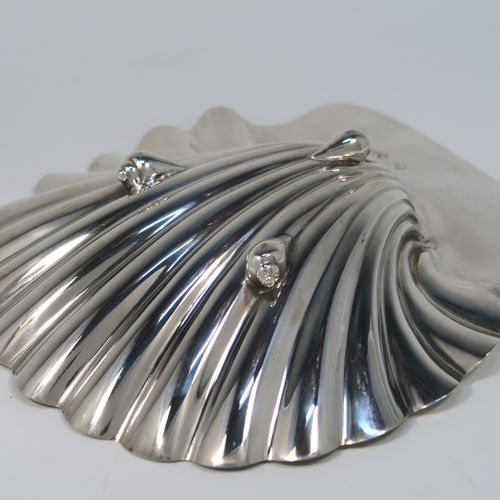 A very handsome pair of Antique early Victorian Sterling Silver butter shells, having hand-chased scalloped bodies, shaped thumb-pieces with applied reeded borders, and both sitting on three cast Conch shell-shaped feet. These beautiful antique silver butter shells were made by Mary and Richard Sibley of London in 1839. The dimensions of these fine hand-made antique silver butter dish shells are length 15 cms (6 inches), width 14 cms (5.5 inches), and they have a total weight of approx. 248g (8 troy ounces).