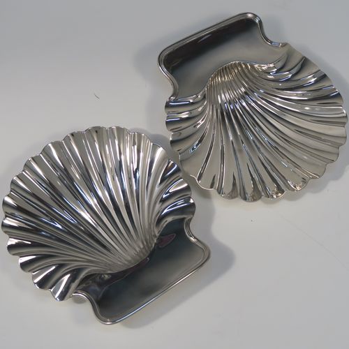 A very handsome pair of Antique early Victorian Sterling Silver butter shells, having hand-chased scalloped bodies, shaped thumb-pieces with applied reeded borders, and both sitting on three cast Conch shell-shaped feet. These beautiful antique silver butter shells were made by Mary and Richard Sibley of London in 1839. The dimensions of these fine hand-made antique silver butter dish shells are length 15 cms (6 inches), width 14 cms (5.5 inches), and they have a total weight of approx. 248g (8 troy ounces).