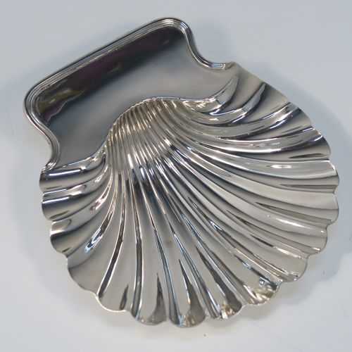 A very handsome pair of Antique early Victorian Sterling Silver butter shells, having hand-chased scalloped bodies, shaped thumb-pieces with applied reeded borders, and both sitting on three cast Conch shell-shaped feet. These beautiful antique silver butter shells were made by Mary and Richard Sibley of London in 1839. The dimensions of these fine hand-made antique silver butter dish shells are length 15 cms (6 inches), width 14 cms (5.5 inches), and they have a total weight of approx. 248g (8 troy ounces).