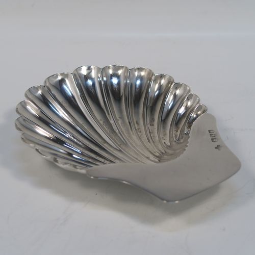 A very pretty Antique Victorian Sterling Silver butter shell dish, having a hand-chased scalloped body, a plain flat side handle, and all sitting on three ball feet. This beautiful antique silver butter shell was made by Horace Woodward of London in 1895. The dimensions of this fine hand-made antique silver butter dish shell are length 13 cms (5.25 inches), width 10 cms (4 inches), and it weighs approx. 69g (2.2 troy ounces).  