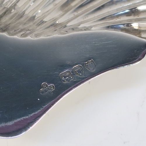 A very pretty Antique Victorian Sterling Silver butter shell dish, having a hand-chased scalloped body, a plain flat side handle, and all sitting on three ball feet. This beautiful antique silver butter shell was made by Horace Woodward of London in 1895. The dimensions of this fine hand-made antique silver butter dish shell are length 13 cms (5.25 inches), width 10 cms (4 inches), and it weighs approx. 69g (2.2 troy ounces).