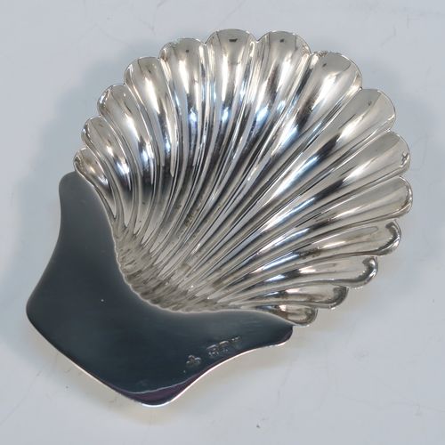 A very pretty Antique Victorian Sterling Silver butter shell dish, having a hand-chased scalloped body, a plain flat side handle, and all sitting on three ball feet. This beautiful antique silver butter shell was made by Horace Woodward of London in 1895. The dimensions of this fine hand-made antique silver butter dish shell are length 13 cms (5.25 inches), width 10 cms (4 inches), and it weighs approx. 69g (2.2 troy ounces).
